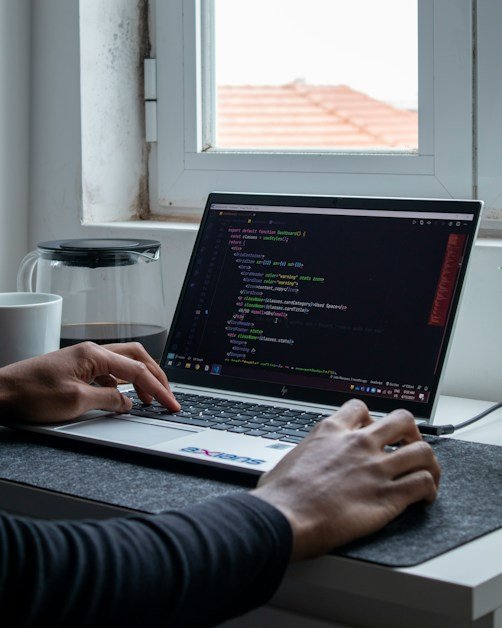 Developer writing code on a laptop